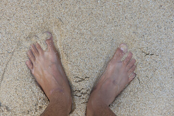 Bare feet on sandy beach with vacation mood.