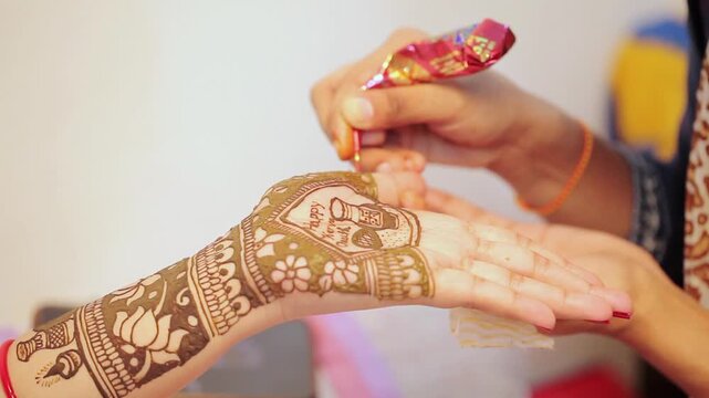 Mehndi being applied on a woman&rsquo;s hand as part of puja preparation for Indian festivals