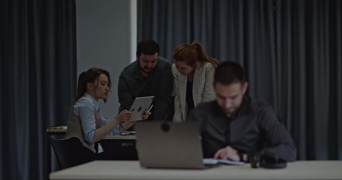 Students collaborate on a project, using a tablet and laptop in a classroom setting.