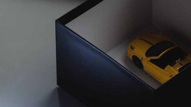 Gift box opens to reveal a model car with a bow during a surprise unboxing moment