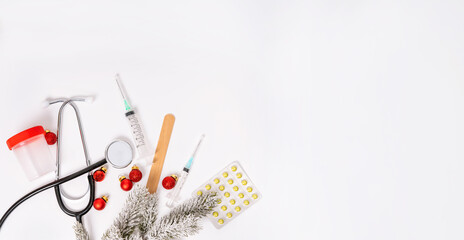 Top flat lay with a medical theme and merry Christmas and a happy new year. Syringes and pills mixed with Christmas toys. Isolated white background.