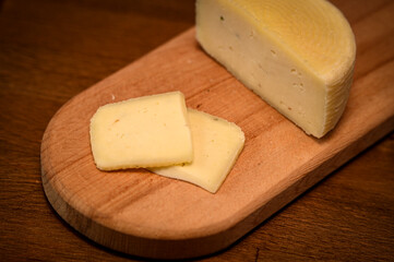 Craft cheese cut into pieces on a cutting board