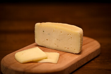 cheese sliced ​​on a wooden board