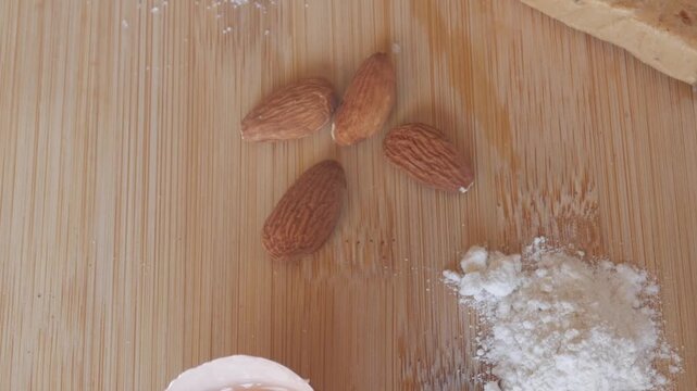 Almonds and flour on wooden board, key for soft Spanish turron de almendra