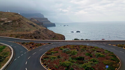 Coastal roundabout surrounded green vegetation on rocky cliffs overlooking ocean