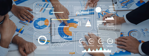 A dynamic team meeting focused on data analysis, showcasing various charts and graphs on the table, highlighting collaborative efforts in strategic planning and decision-making. Trope