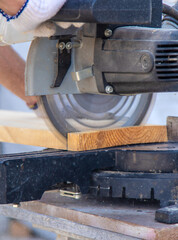 A man cuts wood with a sawmill. Selective focus.
