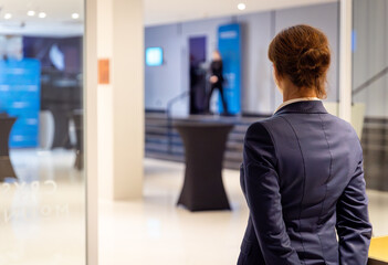 Manager of the hotel restaurant awaits guests at the entrance, rear view