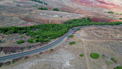 Aerial cars moving road surrounded red rocky hills. Transport riding highway