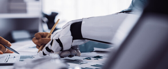 An innovative scene depicting human hands collaborating with a robotic hand in a contemporary office setting, focusing on data analysis for effective business strategies.Noogenesis