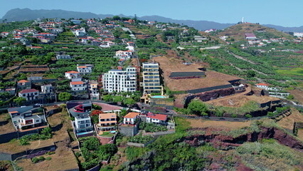 Drone green residential area on terraced hills sunny day. Aerial town districts