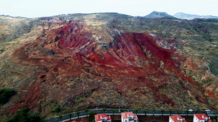 Red rocks looping village with tiled rooftops buildings drone view. Stone cliffs