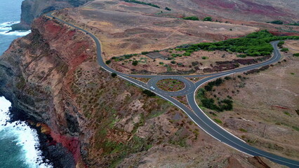 Aerial roundabout rocky shore washed stormy ocean water. Car travelling road 