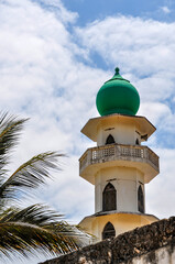 Kenya, Africa: palm tree an the minaret of the old mosque (Juma Mosque) of Malindi, built on the site where until the beginning of the 20th century there was a slave market