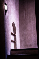 Oman: purple light on a stair with wall lamp at Nizwa Fort, castle in Nizwa built in the 1650s even if its underlying structure goes back to the 12th century, Oman's most visited monument
