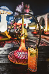 Hookah e drink in lounge notturno con installazioni luminose fantasy e funghi giganti
