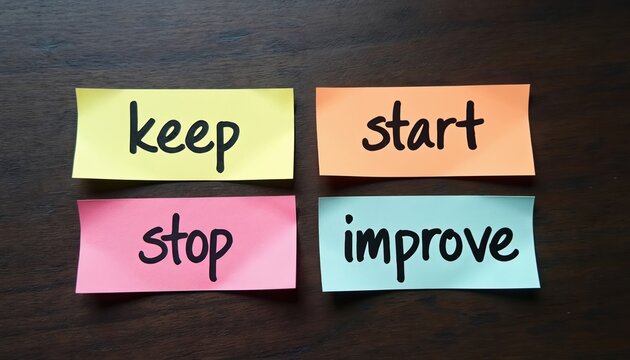 Colorful sticky notes with words keep start stop improve on wooden desk. Business concept for gathering feedback in retrospective meeting. Agile scrum method for teamwork development, continuous