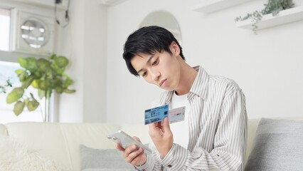 マイナ保険証を設定するアジア人男性