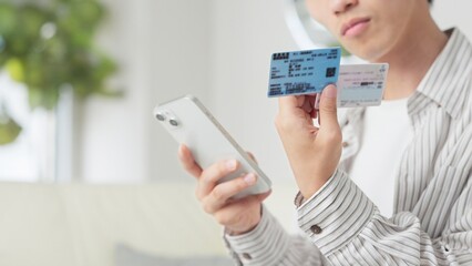 マイナ保険証を設定するアジア人男性