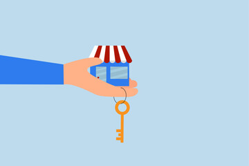 Small business key to success, businessman hand hold small business shop with golden key.