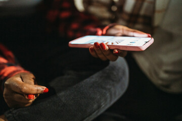 crop anonymous female taking checking messages on a mobile phone at night