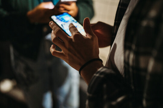 side view of crop anonymous male using mobile phone at night