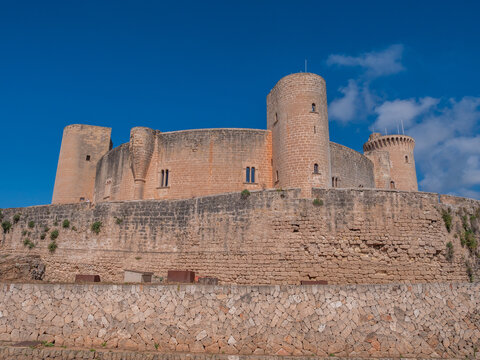 Castell de Bellver, Palma Mallorca, historic castle with multiple round towers stands majestically on a stone wall, clear blue sky, Majorca