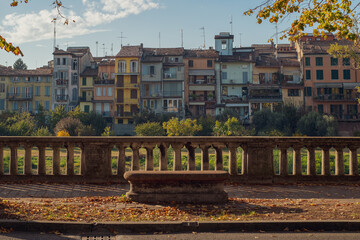 Stone bench on the Parma riverfront. Typical Parma houses. Colorful houses along the riverfront. Autumn.
