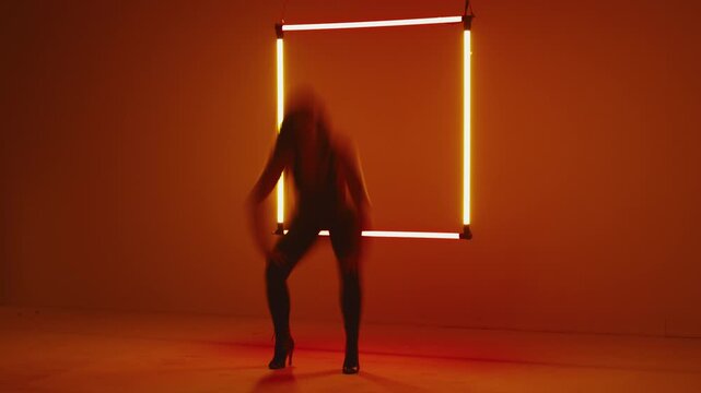 Timelapse captures the woman&rsquo;s energetic dance, motions speeding up, neon glowing square in background