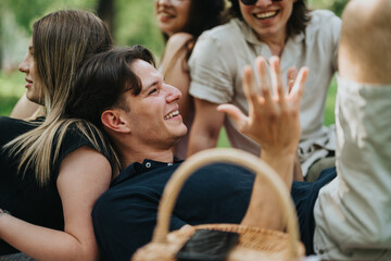 Fototapeta premium Group of friends enjoying quality time together in a serene park on a sunny day, featuring smiles, laughter, and a relaxed atmosphere.