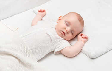 a four-month-old baby sleeping in a bed