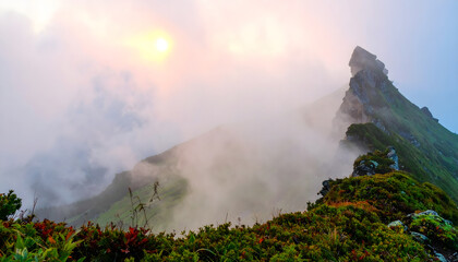 a Cloudy Mountain Landscape During Sunrise or Sunset, Fog Covered Scene Creating a Mystical and Serene Natural Atmosphere