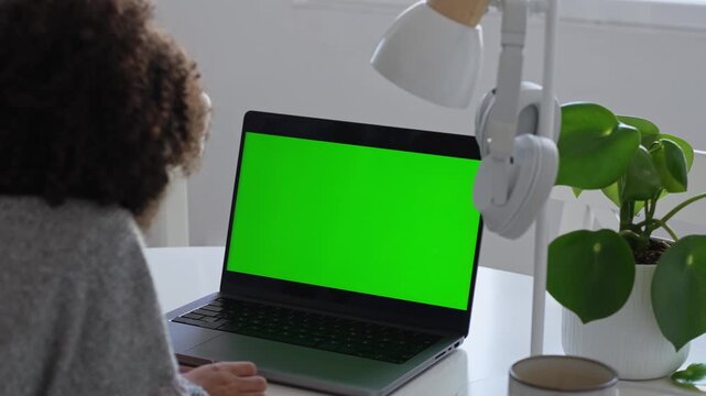 Primary school Student African American child with headphones using laptop green screen chroma key. Distance learning online education. Schoolboy girl studying at home with digital tablet computer and