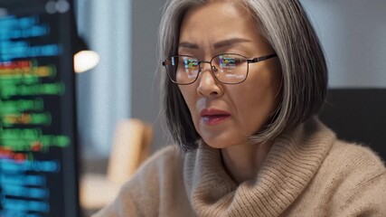 Asian Woman Correcting Glasses While Working on Software Code