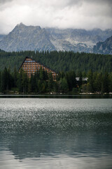 Triangular Building by Lake and Mountains