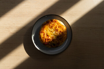 A small pizza with cheese and pineapple.
