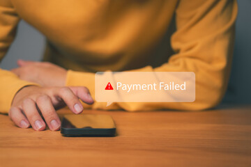 Close-up of hand using smartphone with “Payment Failed” alert message, representing online transaction error, declined payment, banking problem, or digital finance security issue in mobile app.