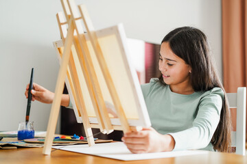 Female kid painting at home - Education, art and creativity for children concept - Main focus on face