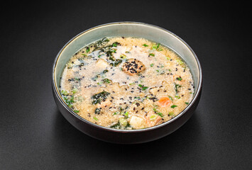 Rich kim chi soup with trout, tofu. Wakame seaweed, rice, chicken egg and sesame seeds.