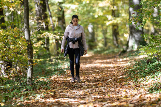 Woman walking on autumn forest path