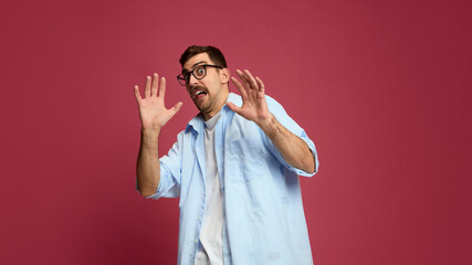 Frightened man raising hands in defensive gesture with scared expression. Concept of mental health awareness, panic attack illustration, fear response, and stress management psychology.