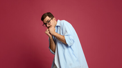 Nervous man covering face with fists expressing fear and anxiety. Concept of stress, mental health, panic, psychological reaction, and emotional struggle in awareness campaigns.