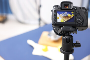 Shooting fresh lemons and juicer with camera in studio, selective focus. Professional food photography