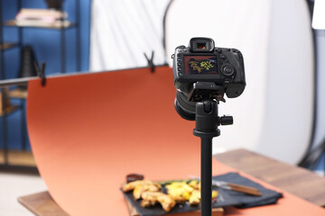 Shooting chicken wings, potato wedges and spices with camera in studio, selective focus. Professional food photography