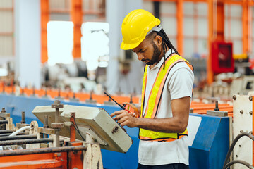 Professional African black worker working machine operator in heavy industry factory supervisor