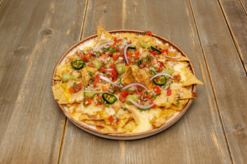 Vegetarian nachos with black beans, sweet corn, roasted bell peppers, and evenly melted panela cheese