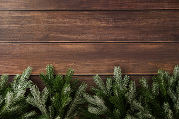 Snowy pine branches on bottom edge of wooden background. Christmas card design, New Year banner...