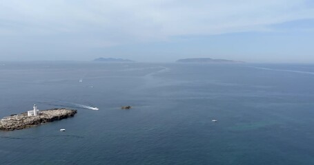 Aerial view of the Palumbo Rock with the Palumbo lighthouse in the Bay of Trapani, Sicily, Italy. The Aegadian Islands are in the background.