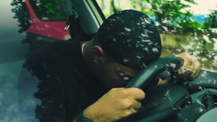 Man leaning forward with head pressed against steering wheel, conveying exhaustion, despair, and silent emotional breakdown during stressful moment inside car