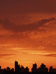 Stunning City Skyline Glowing in Orange Hues Against an Evening Sky with Dramatic Clouds and Soft Light